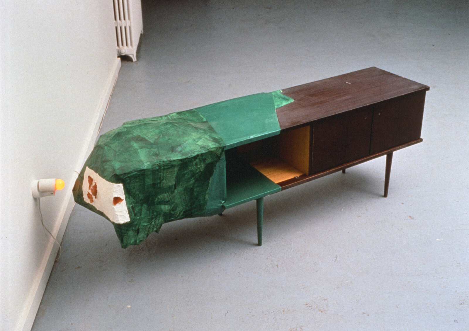 Jessica Stockholder, Kissing the Wall Out of Sequence, 1989, low table, paper maché, enamel paint, orange peels, lamp