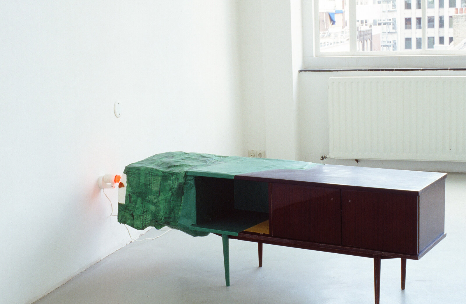 Jessica Stockholder, Kissing the Wall Out of Sequence, 1989, low table, paper maché, enamel paint, orange peels, lamp