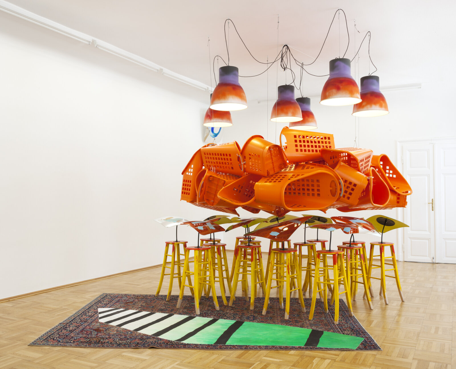 Jessica Stockholder, Lay of the Land, 2014, plastic shopping baskets, driveway mirrors, carpet, 15 wooden stools, acrylic paint, pendant lights and bulbs, hardware, 136 x 138 x 108 in. (345 x 350 x 275 cm)