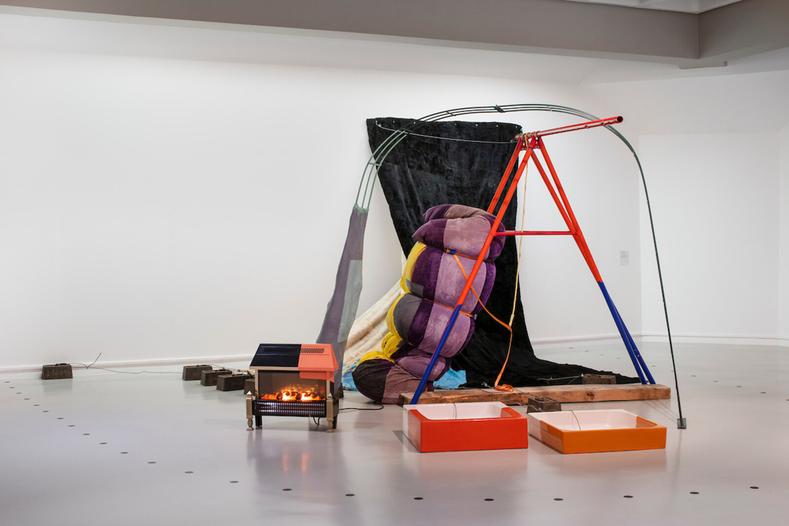 Jessica Stockholder, Torque, Jelly Role, and Goose Bump, 1997, paper maché, heater, 2 shower trays, acrylic and enamel paint, fur, sofa, swing, 120 x 239 x 232 in. (305 x 608 x 590 cm)