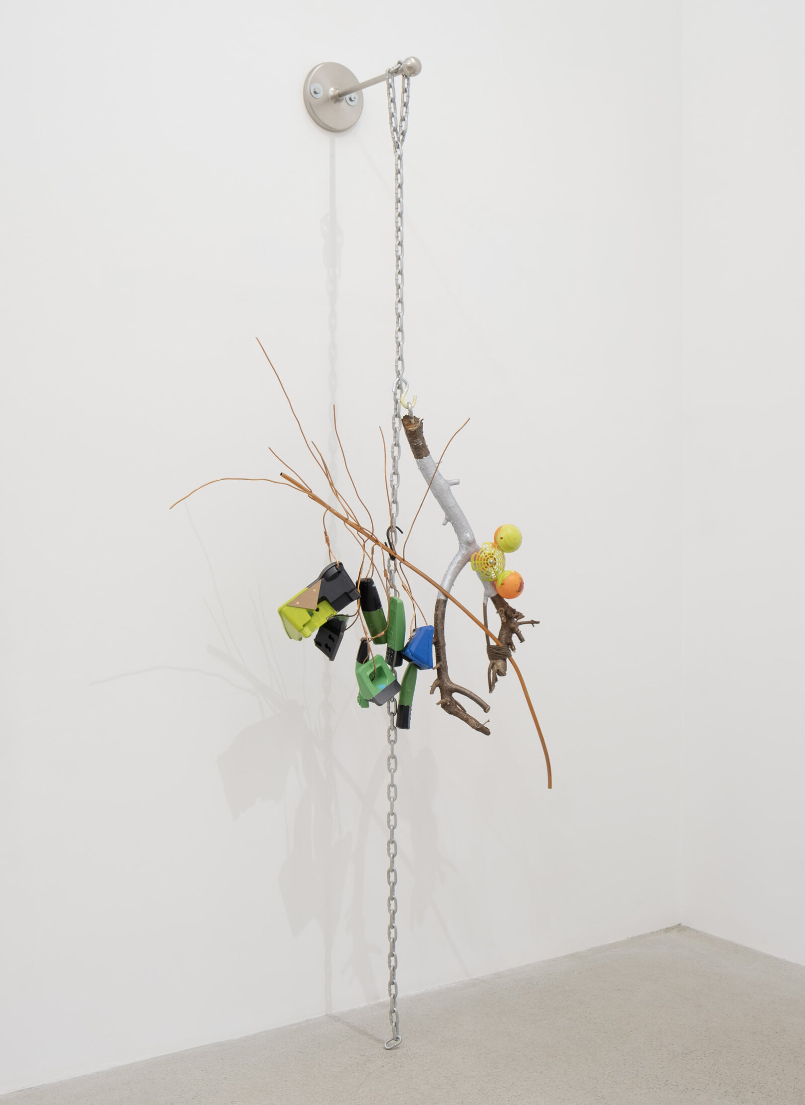 Jessica Stockholder, JS530, 2012, branches, phones, plastic, chain, copper tubing, yarn, acrylic paint, linoleum, hardware, 89 x 37 x 17 in. (226 x 94 x 43 cm)