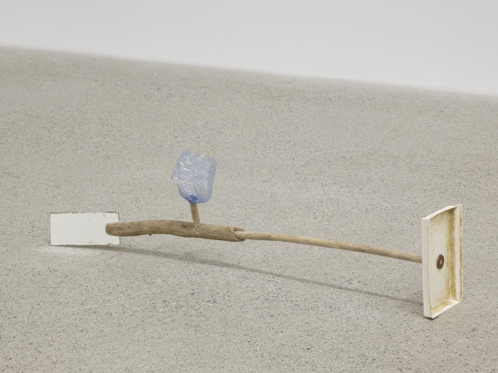 Ashes Withyman, Under a mouldy sky (spent tire, slab of stone, torn barbed wire fence), 2019, branches, margarine container base, penny, portion of water bottle, mirror, 7 x 26 x 4 in. (18 x 66 x 10 cm)